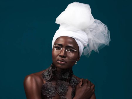 Black woman, makeup and fashion with traditional african clothing, confidence and self love on dark studio background. Portrait, face and head wrap of female model in outfit for culture expression.