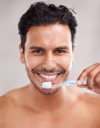 Dental, portrait and man in bathroom for brushing teeth, self care and morning routine. Oral hygiene, smile and face of Mexican male person at home for wellness, toothbrush and healthy mouth