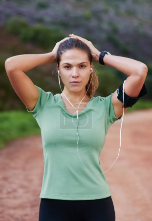 Photo for Fitness, portrait and woman tired on run and breathing to rest with music in headphones in exercise or workout. Athlete, break and girl training in summer with resilience for challenge in countryside. - Royalty Free Image