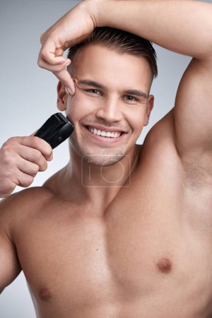 Photo for Portrait, shave and razor with man in studio, skincare and hygiene for facial grooming. Cosmetic, hair removal and wellness for dermatology, maintenance and electric cleaning tool on background. - Royalty Free Image