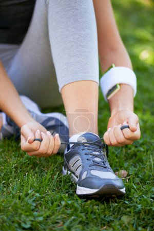 Photo for Sneakers, hands and tie shoelace in park, ready for run or cardio for fitness and sports outdoor. Exercise, workout and person with shoes on grass for training, health and wellness with runner. - Royalty Free Image