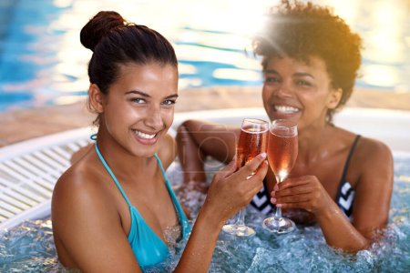 Photo for Women, friends and wine in jacuzzi in portrait, self care and pamper day at spa for wellness and cold beverage. Water, bubbles and alcohol drink in hot tub for detox and friendship date for bonding. - Royalty Free Image