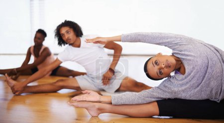 Téléchargez les photos : Danse, classe et les gens étirant les jambes sur le sol pour commencer la répétition ensemble dans le studio ou l'académie. Entraînement, corps et exercice sain pour la remise en forme à l'école créative avec yoga ou entraînement pilates. - en image libre de droit