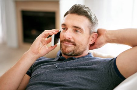 Photo for Home, relax and phone call with man, conversation and contact with technology and mobile user. Person on a couch, apartment and guy with smartphone and speaking with discussion, talk and listening. - Royalty Free Image