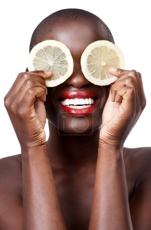 Téléchargez les photos : Femme noire, sourire et soin citron en studio en dermatologie bio de routine ou bien-être. Fond blanc, visage et heureux modèle africain avec fruits du visage, alimentation et produits pour les yeux pour la beauté. - en image libre de droit
