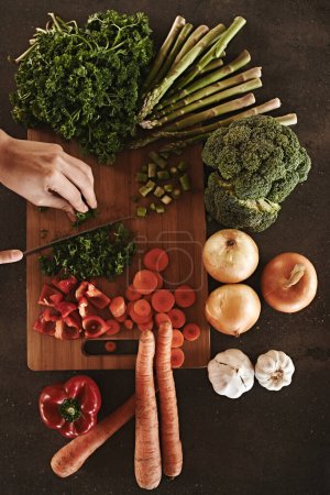 Photo for Healthy, hands and knife with vegetables, chopping board and food with ingredients and wellness. Closeup, utensils and chef with salad and lunch with diet plan and dinner meal . with vegan and person. - Royalty Free Image