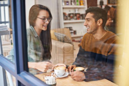Photo for Happy couple, relax and date with coffee at cafe for conversation, bonding or romance at indoor restaurant. Man and woman with smile by window and enjoying drink, beverage or morning caffeine at shop. - Royalty Free Image