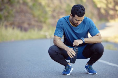 Man, watch and tired athlete on break tracking training on mountain path for exercise, goals or check. Male person, street and resting with heart rate pulse for marathon running, workout or healthy.