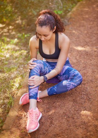 Photo for Knee pain, woman and injury in runner outdoors for fitness, exercise and jogging in nature. Female person, athlete and hurting leg from training, workout and sitting outside for rest in the shade. - Royalty Free Image