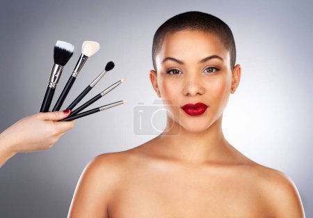 Photo for Hand with brush, cosmetics and woman in portrait by studio background for wellness, beauty or makeup with pride. Cosmetology, female model and products for application, aesthetics or facial treatment. - Royalty Free Image