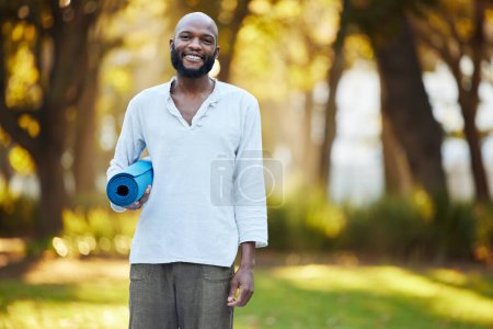 Photo for Man, portrait and park for yoga with mat, fitness and healing outdoor, happy and healthy with exercise in morning. Spiritual, African yogi and pilates for workout, wellness and self care in nature. - Royalty Free Image
