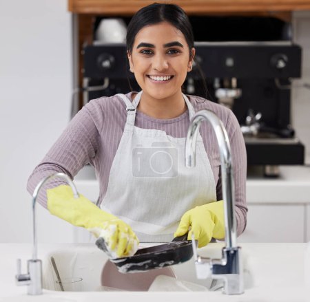 Photo for Smile, portrait and woman washing dishes in home for cleaning, hygiene and housework in kitchen. Face, soap and sponge on pan with foam for dirt, safety or maid with chores for housekeeping in Brazil. - Royalty Free Image