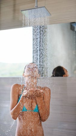 Photo for Showering, wet and woman with wellness, bikini and healthy with morning routine and body. Person, hotel and girl with water and underwear with cleaning, grooming and happy with hospitality and liquid. - Royalty Free Image