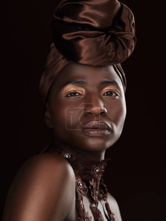 Photo for African, portrait or woman with makeup, turban or necklace in studio on black background in Ghana. Skincare, face and proud model with beauty, eyeshadow cosmetics and traditional fashion for culture. - Royalty Free Image