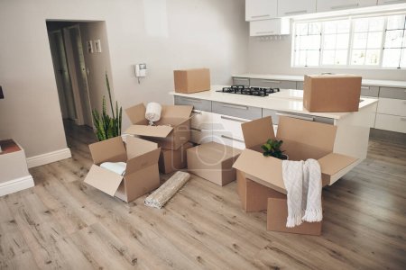 Photo for Room, boxes and relocation for moving, apartment and new home with belongings, unpack and no people. Cardboard, mortgage and property for real estate, packaging and kitchen counter in modern house. - Royalty Free Image