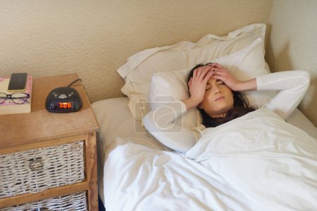 Photo for Home, stress and woman wake up with headache, sick or morning insomnia in bedroom with burnout. Bed, migraine and tired girl with fatigue for anxiety, pain or frustrated of depression in apartment. - Royalty Free Image