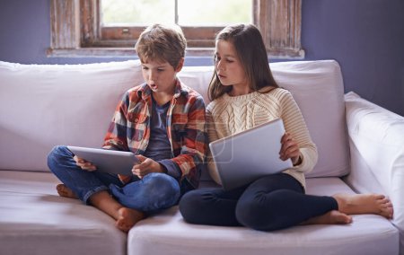 Photo for Boy, girl and tablet for gaming on couch together, technology and online streaming for bonding at home. Digital .world, internet with kids or sibling in living room, gamer app or elearning with ebook. - Royalty Free Image