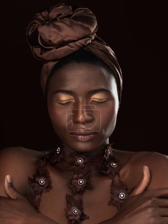 Foto de Mujer africana, turbante y maquillaje de fondo oscuro con elegancia, pose y manos para la cultura tradicional. Reina negra, piel y cosméticos en estudio con belleza, ojos cerrados y herencia de Nigeria. - Imagen libre de derechos