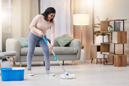 Photo for Happy, woman and cleaning floor in home with mop for hygiene with detergent for safety or protection from germs . Smile, housekeeper or service for health or wellness from virus or bacteria in lounge. - Royalty Free Image