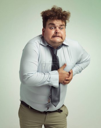 Photo for Frustrated man, plus size and heart attack with cardiac arrest or ache on a studio background. Male person or model with pain, body fat or cholesterol in obesity, unhealthy or overweight on mockup. - Royalty Free Image