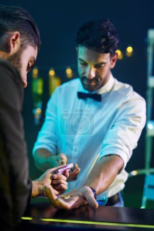 Photo for Man, bartender and dealing drugs in nightclub for party, disco and rave in bar. Buying pills, dealer and cash in club for nightlife in urban city for crime, money laundering and dope or ecstasy. - Royalty Free Image
