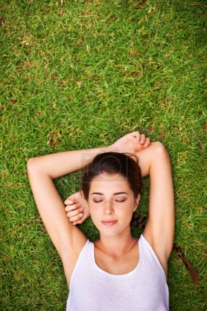Téléchargez les photos : Femme, couchage et vue sur l'herbe pour se détendre avec portrait, bronzage et week-end en été. Jeune, sieste et repose sur la pelouse, le jardin et l'arrière-cour de la maison pour l'air frais sur l'espace de maquette. - en image libre de droit