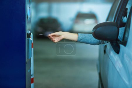 Parking lot, car and hand with ticket meter for payment, cost and access for security, safety or garage space compliance. Machine, card or driver with vehicle permit pass for toll, barrier or fees.