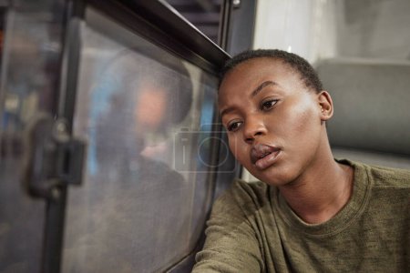 Foto de Mujer, viajar y deprimido por la ventana en tren con mala memoria, triste y solo en el transporte público. Chica africana, persona y cansado de la ansiedad, perdido o estrés para el futuro en el metro en el viaje en tren. - Imagen libre de derechos