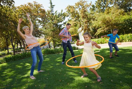 Photo for Parents, kids and hula hoop in park for playing, child development and motor skills outdoor. Children, son and daughter with mom and dad in nature for leisure, family time and bonding with smile. - Royalty Free Image