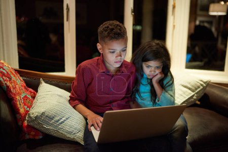Photo for Siblings, kids and home with laptop at night on streaming platform or service for movies and entertainment. Family, child development and learning with online games for education, knowledge and fun. - Royalty Free Image