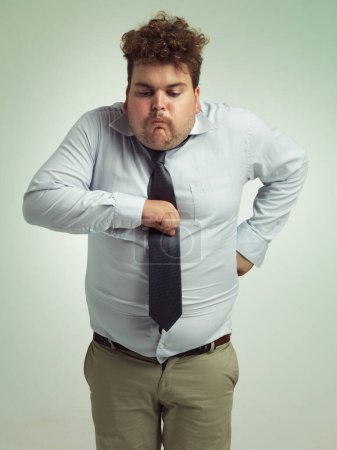 Plus size, sick and man with vomit, abdomen and unhealthy with double chin, stomach and fat in body. Ill, male person and guy retching in studio, professional and suit for work, adult and employee.