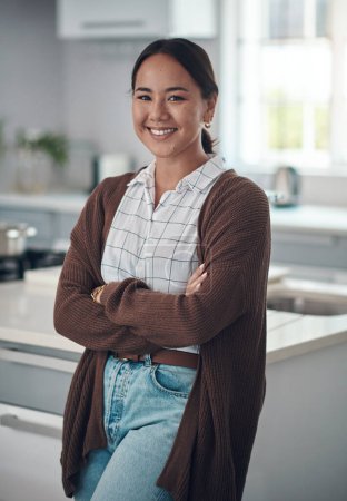 Photo for Happy, asian woman and arms crossed, thinking in portrait for cooking new recipe in kitchen. Happiness, female person and smile with casual outfit for wellness, home decoration and fresh apartment. - Royalty Free Image