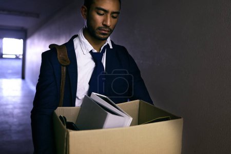 Businessman, fired and sad or stress with box in corridor with unemployment, dismissal and fail. Professional, employee and helpless in work building with bag, leaving and disappointed or depression.
