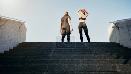Photo for Stairs, fitness and athlete man with woman for resilience, endurance challenge or cardio training in city. Back, runner and friends on steps for performance, power workout or sports achievement. - Royalty Free Image