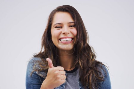 Photo for Happy, portrait and woman with thumbs up support in studio for thank you, congratulations or praise on white background. Yes, face and girl model with OK emoji for success, agree or sign up promotion. - Royalty Free Image