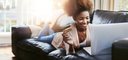 Photo for Credit card, laptop and black woman on sofa in home for online shopping, internet purchase and payment. Ecommerce, fintech and happy person on computer for budget website, sales and digital banking. - Royalty Free Image