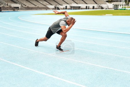 Black man, athlete and start position for running, cardio and fitness on outdoor track field. Male person, health and wellness outside in summer for exercise, training and workout at stadium.