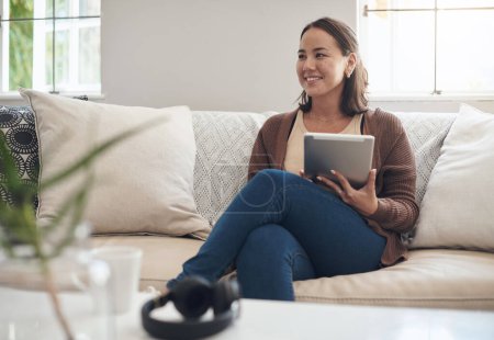 Woman, home and sofa with thinking on tablet for social media post and entertainment in living room. Female person, internet and streaming service or website for news update or online search.