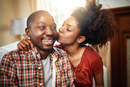 Photo for Kiss, love and black couple on sofa in home with affection, marriage and carefree in living room. Smile, happy man and woman on couch with romantic embrace, gratitude and excited together in house - Royalty Free Image