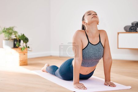 Photo for Cobra pose yoga or woman in home for stretching, wellness or body flexibility in zen studio for peace. Aura, chakra energy or calm girl on mat for mindfulness, meditation or spine in pilates session. - Royalty Free Image