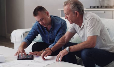 Photo for Father, son and planning with blueprint in home, tablet and together for investment in real estate. Reading, document and paper for property, men and family in business for house, lounge and couch. - Royalty Free Image