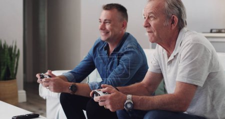 Photo for Father, son and bonding with video games in home, controller and smile for gaming in lounge and sofa. House, family and men online with internet for fun with gamepad, weekend and together on couch. - Royalty Free Image