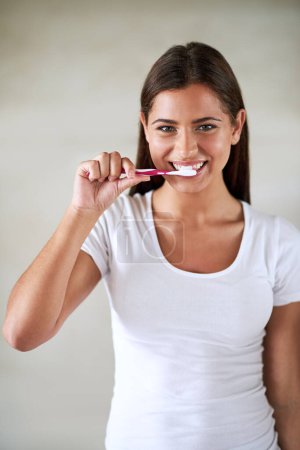 Téléchargez les photos : Portrait, femme et heureux avec brosse à dents en studio sur fond blanc pour l'hygiène et le nettoyage des dents. Femme, sourire et satisfait avec du dentifrice pour une haleine fraîche ou brosser pour la santé buccodentaire. - en image libre de droit