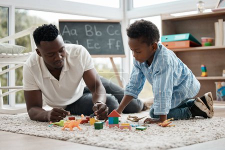 Photo for Father, child and play with toys together in home for learning, entertainment or bonding in living room. Black family, dad and boy in house for kids games, babysitting and relationship development. - Royalty Free Image