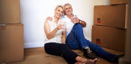 Photo for Boxes, wine and senior couple at new house for cheers in living room for homeownership. Love, mortgage and portrait of elderly man and woman with cardboard package and champagne in apartment together. - Royalty Free Image