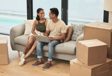 Photo for Couple, laptop and boxes for moving on couch for smile, bonding and streaming in new home. Man, woman and relax on sofa with computer for designs, renovations and break from packing while together. - Royalty Free Image