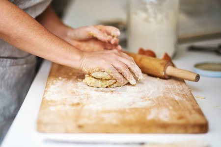 Téléchargez les photos : Pâte, mains et boulangerie dans la cuisine pour biscuits, desserts ou biscuits à la maison avec passe-temps. Cuisson, farine et personne cuisson plat de pâtisserie, tarte ou nourriture pour la cuisine avec épingle et planche à bois à l'appartement - en image libre de droit