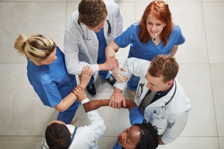 Photo for Doctor, hands together and above with medical team in unity, meeting or motivation at hospital. Top view of happy people or healthcare group touching in collaboration, solidarity or mission at clinic. - Royalty Free Image
