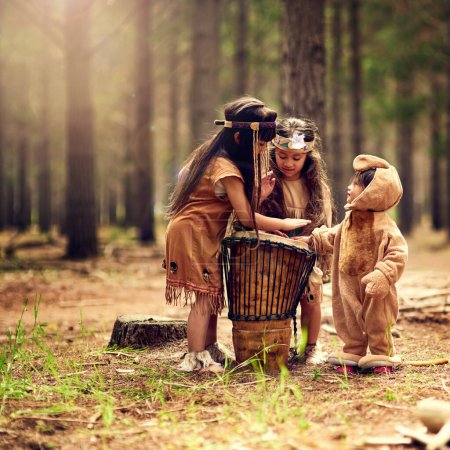 Native American children, drum and music in nature with playing, bonding and connection in woods. Frères, enfants et instruments avec la culture, le patrimoine et l'histoire en forêt avec la famille en Californie.