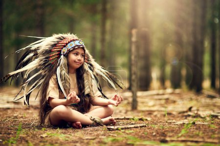 Photo for Native American chief, forest and nature for meditation in childhood for connection with war bonnet in woods. Faith, girl and relax with mindfulness, peace and insight with reflection in California. - Royalty Free Image